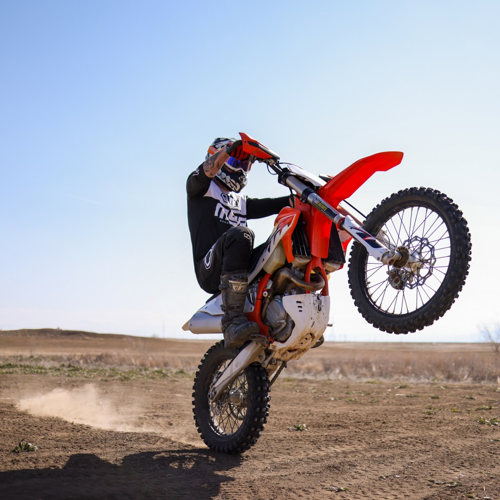 Man Wheelieing a dirt bike in the Colorado Desert