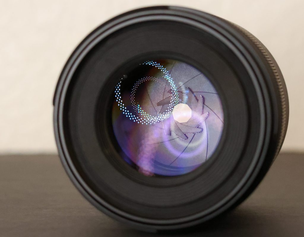 View inside of a canon 85mm f/1.8 lens, looking at the aperture blades