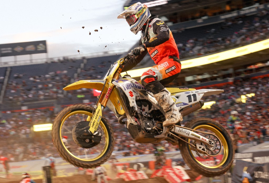 Kyle Chisholm number 11 riding toward roost flying at his face under golden stadium lights.