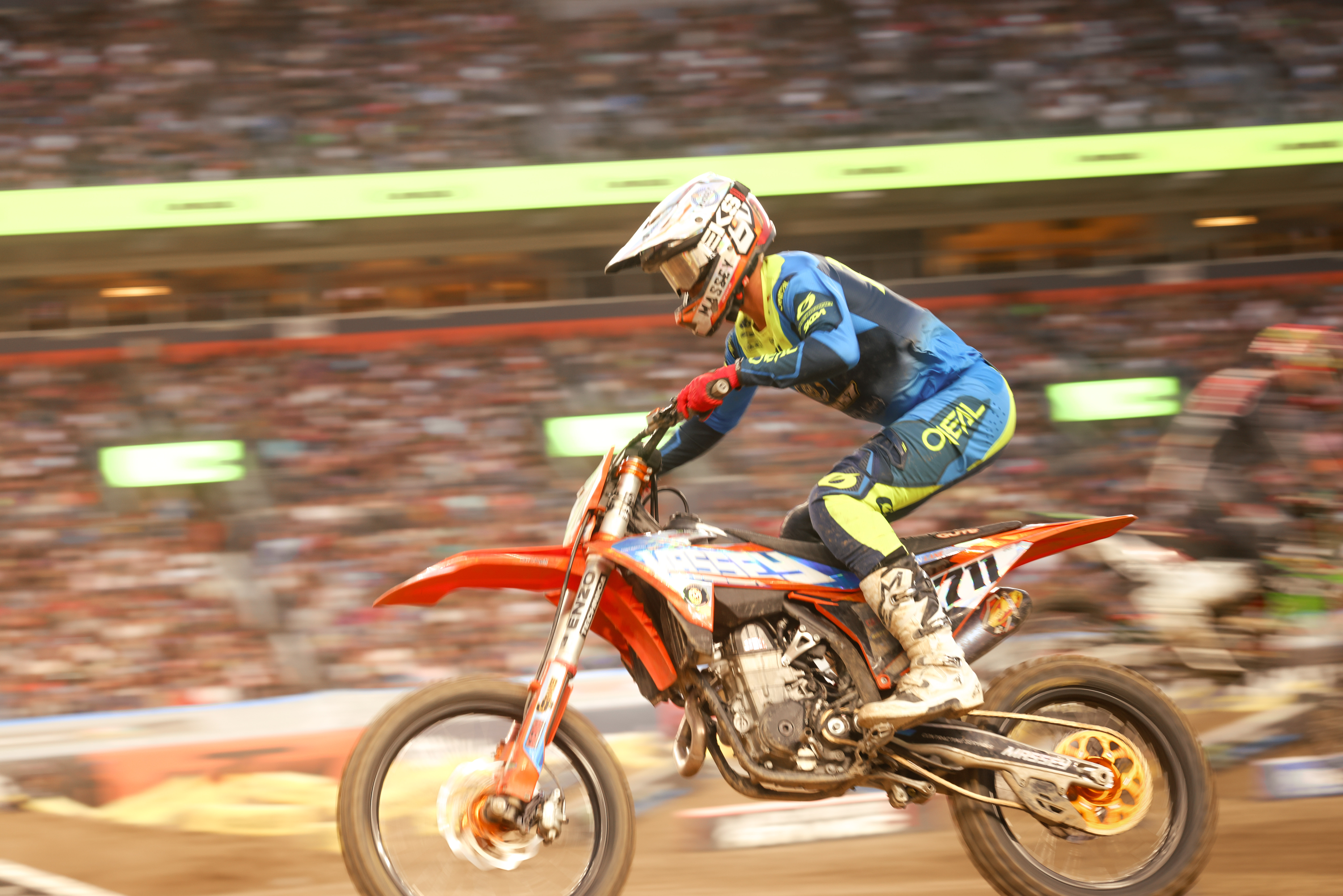 Tristan Lane number 711 riding at high speed in a motion blur with a full stadium behind him.