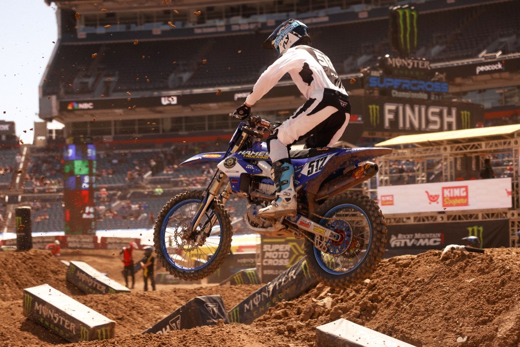 Austin Cozadd number 512 mid-air with dirt chunks frozen behind him.