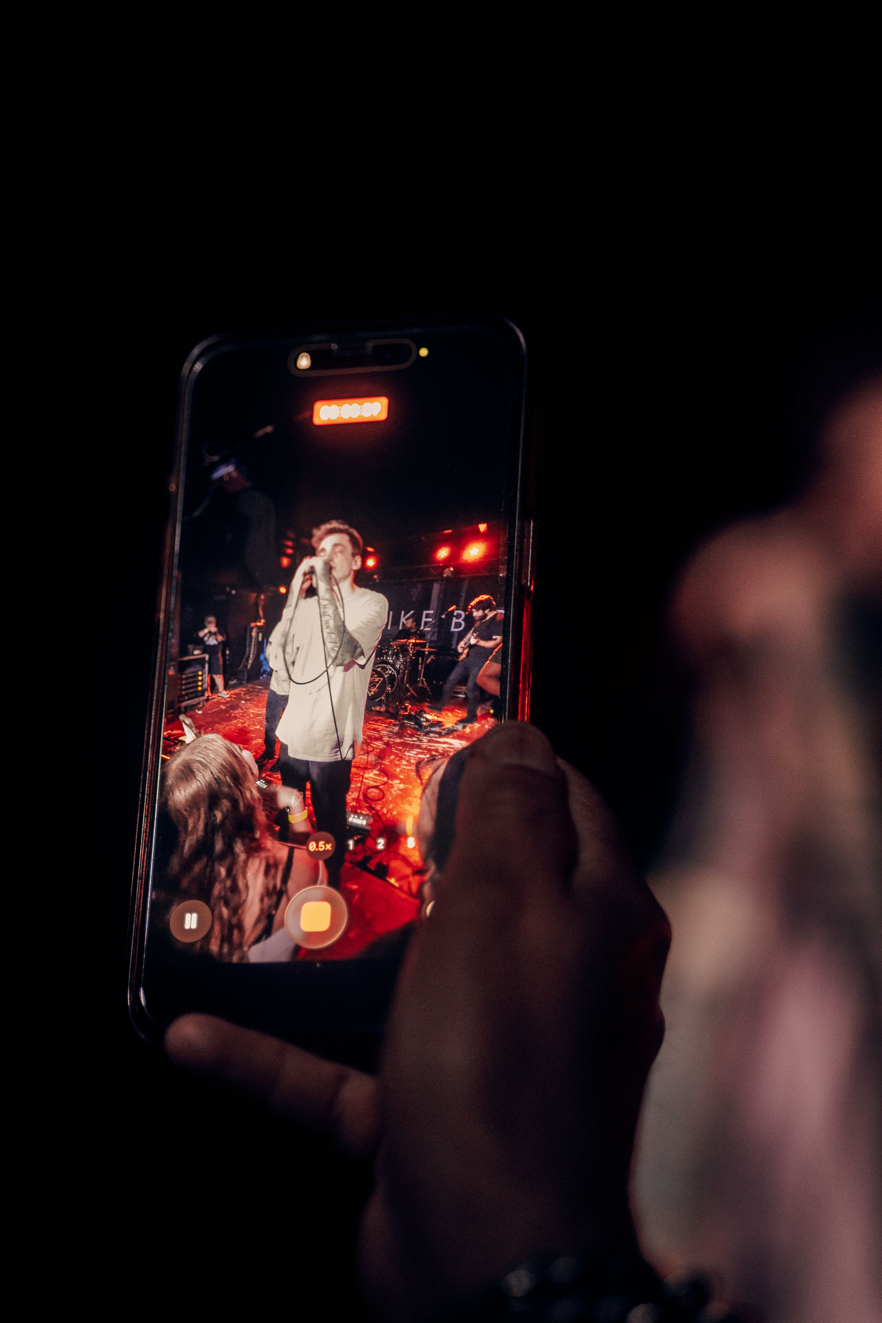Close up of person in the crowd holding phone to record Andy Cizek during A Lot Like Birds Set