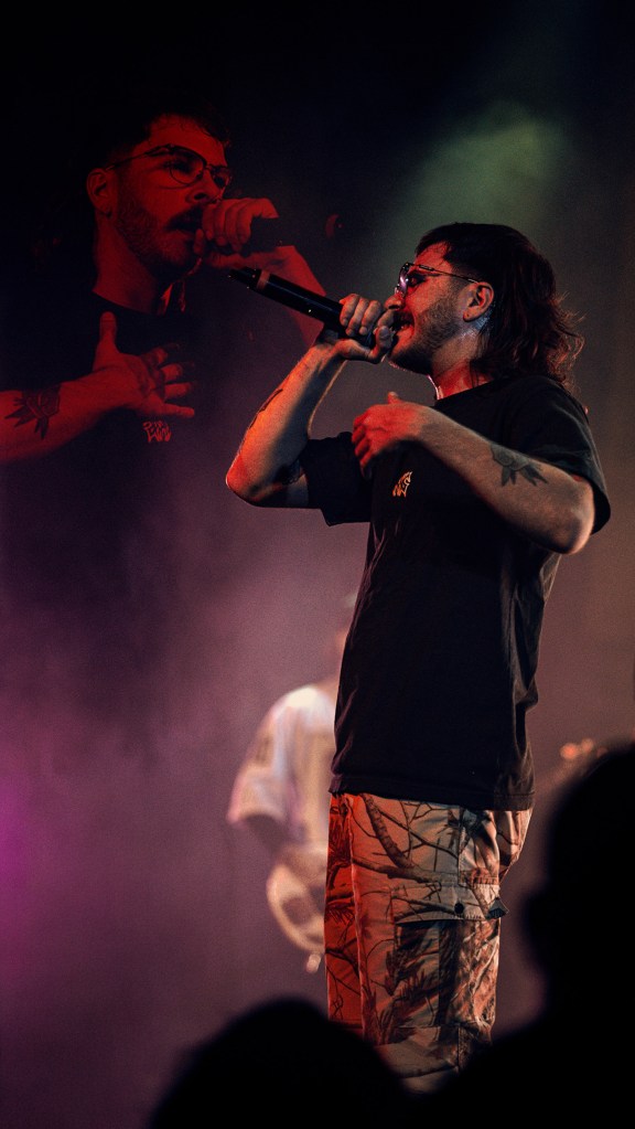 Belmont lead vocalist, Taz Johnson, passionately singing into the mic during their Denver concert at The Oriental Theater.
