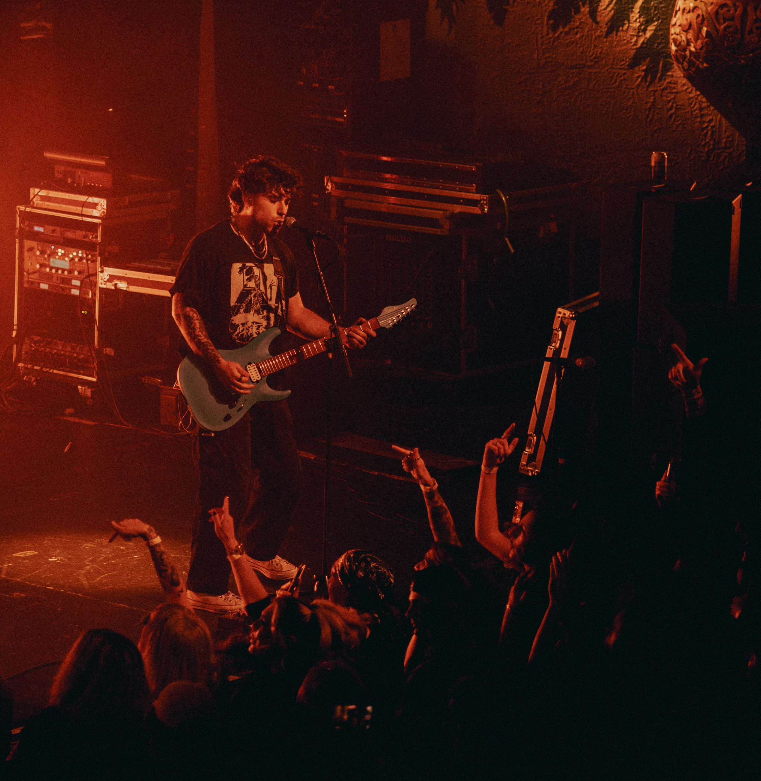 Belmont guitarist playing under stage lights during a live performance in Denver, Colorado.