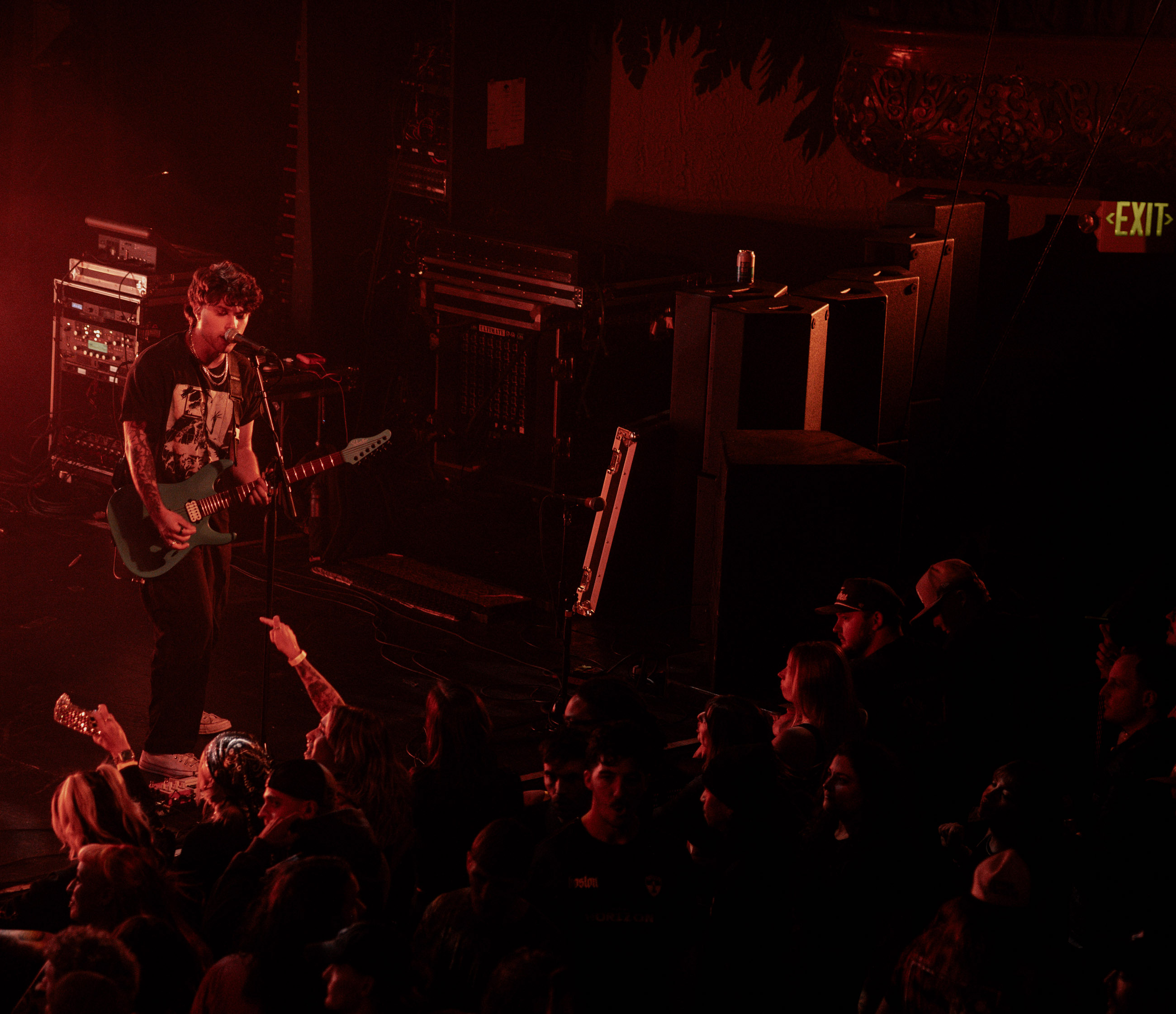Belmont guitarist playing under stage lights during a live performance in Denver, Colorado.