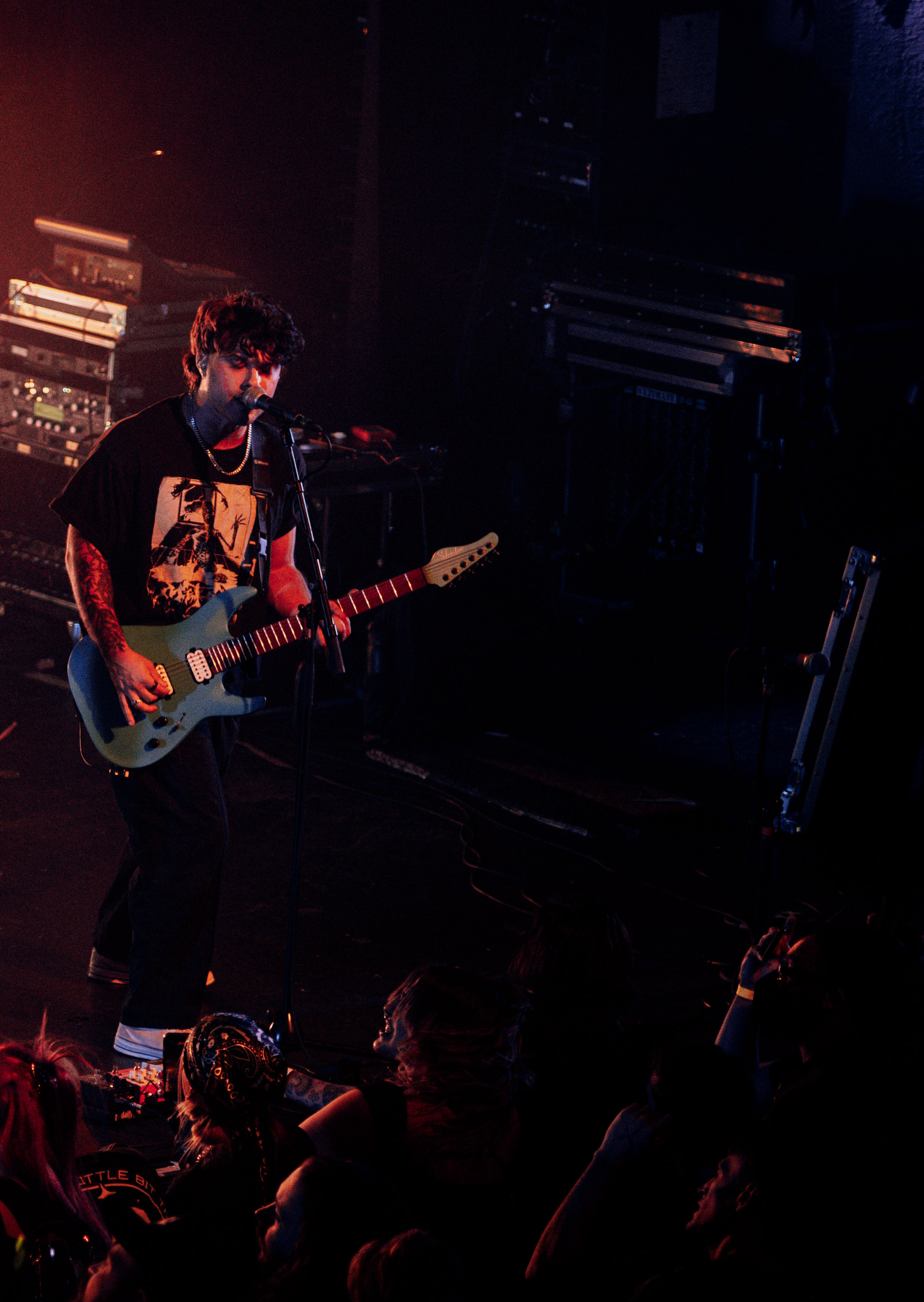 Belmont guitarist playing under stage lights during a live performance in Denver, Colorado.