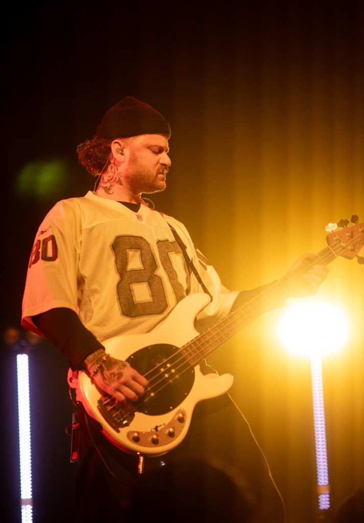 Belmont bassist playing under stage lights during a live performance in Denver, Colorado.