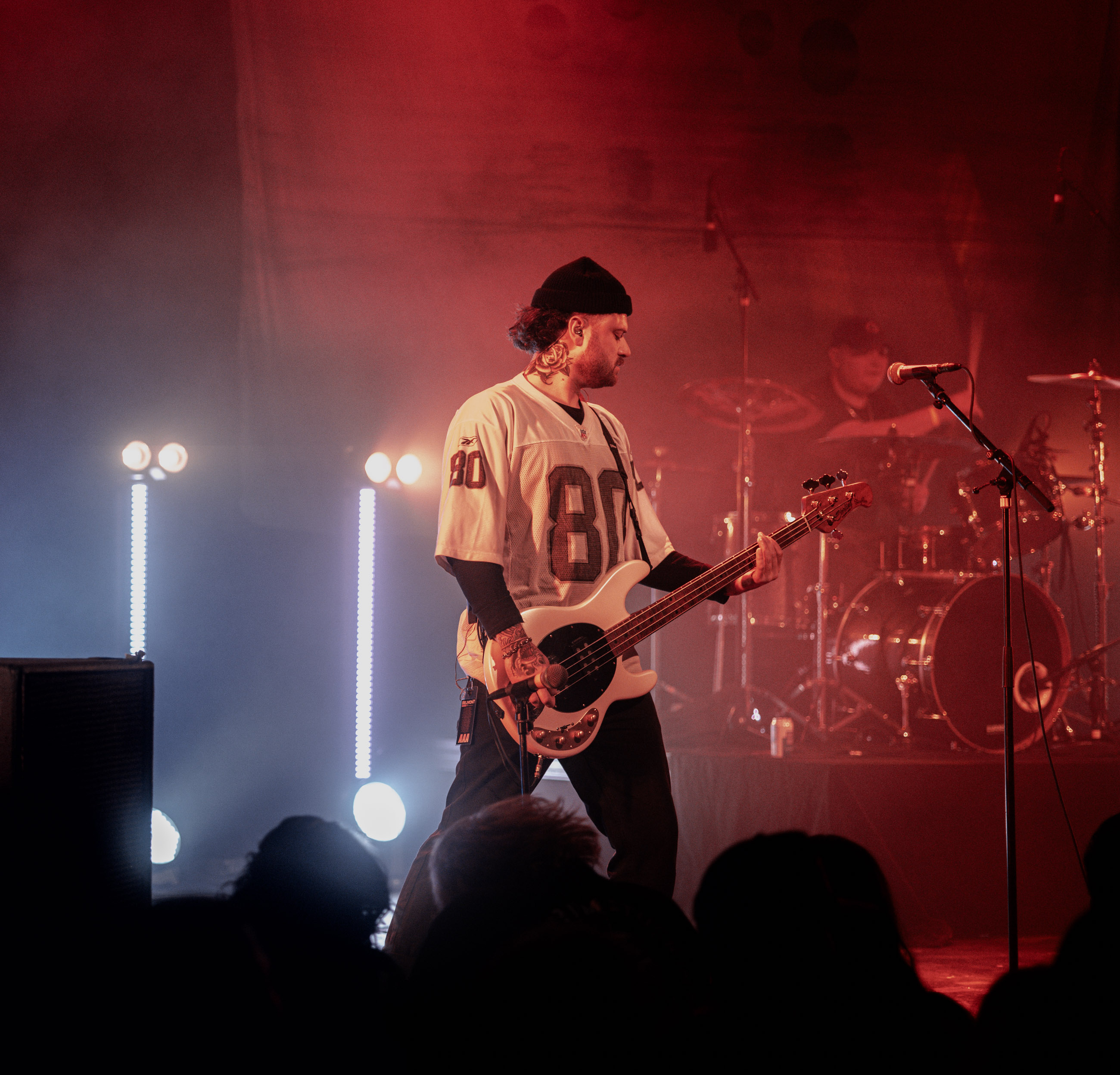 Belmont bassist playing under stage lights during a live performance in Denver, Colorado.