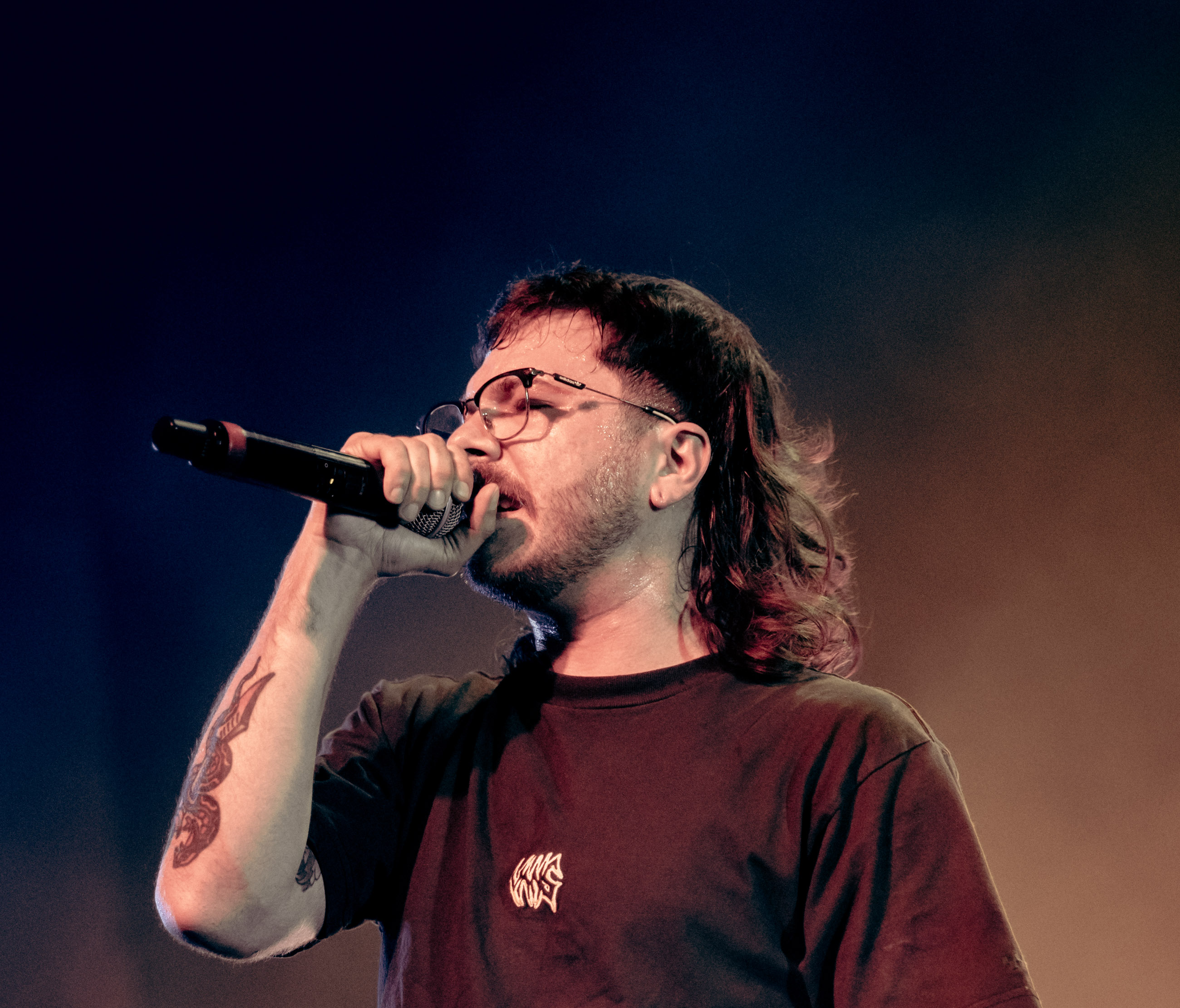 Belmont lead vocalist, Taz Johnson, passionately singing into the mic during their Denver concert at The Oriental Theater.