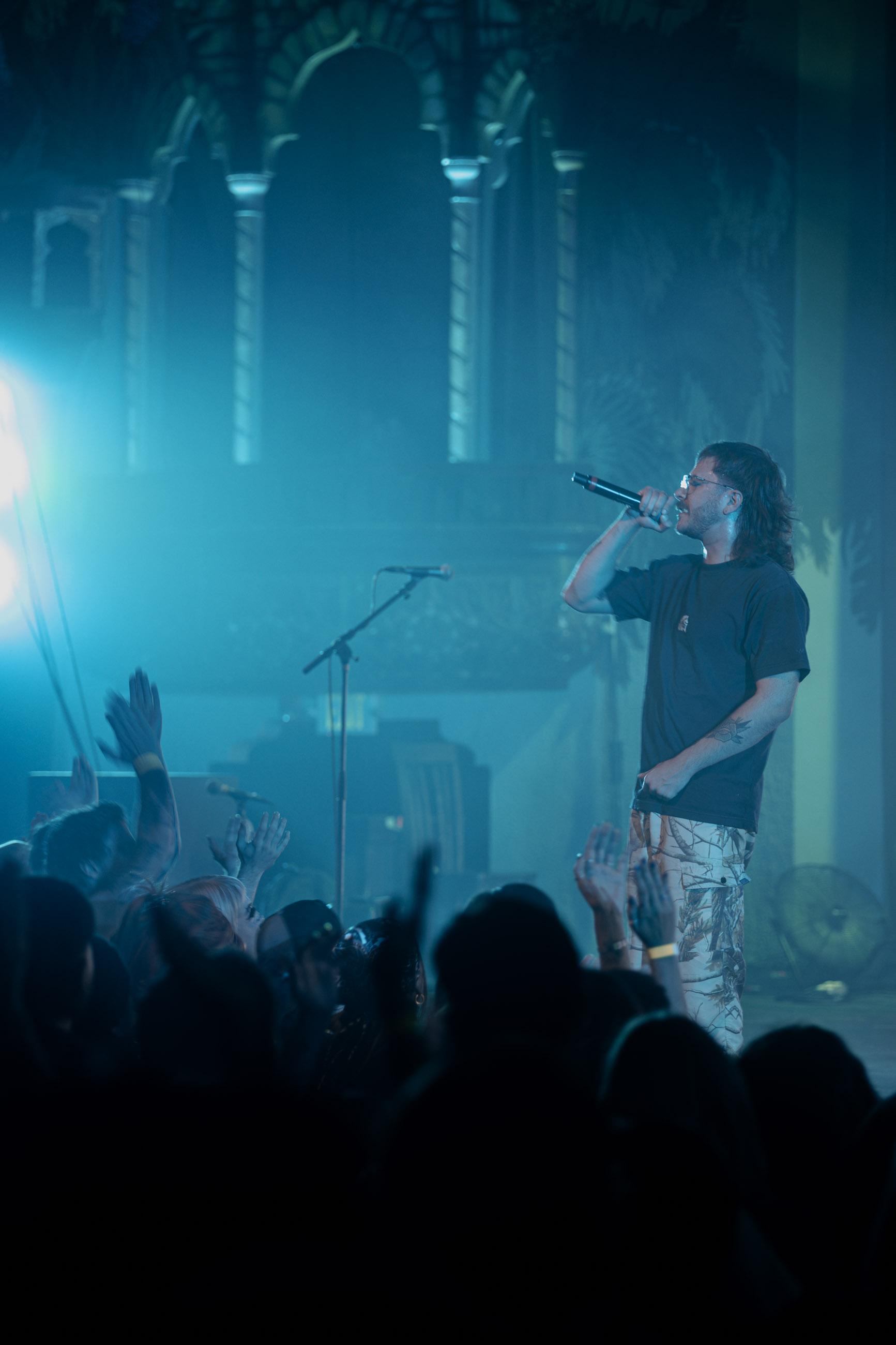 Belmont lead vocalist, Taz Johnson, passionately singing into the mic during their Denver concert at The Oriental Theater.