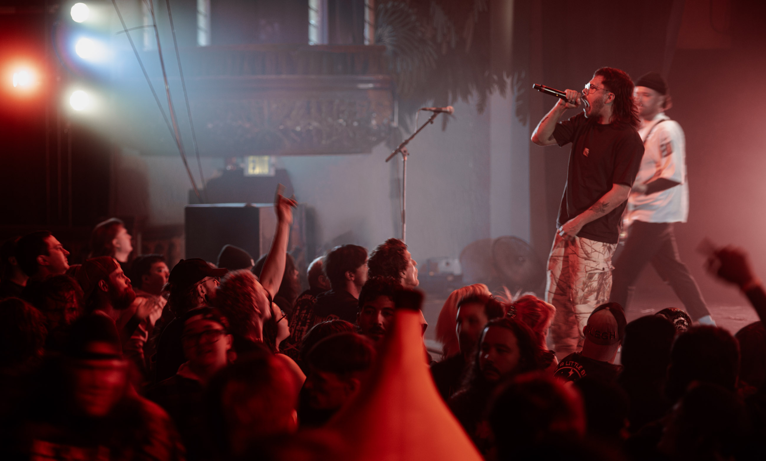 Belmont lead vocalist, Taz Johnson, passionately singing into the mic during their Denver concert at The Oriental Theater.