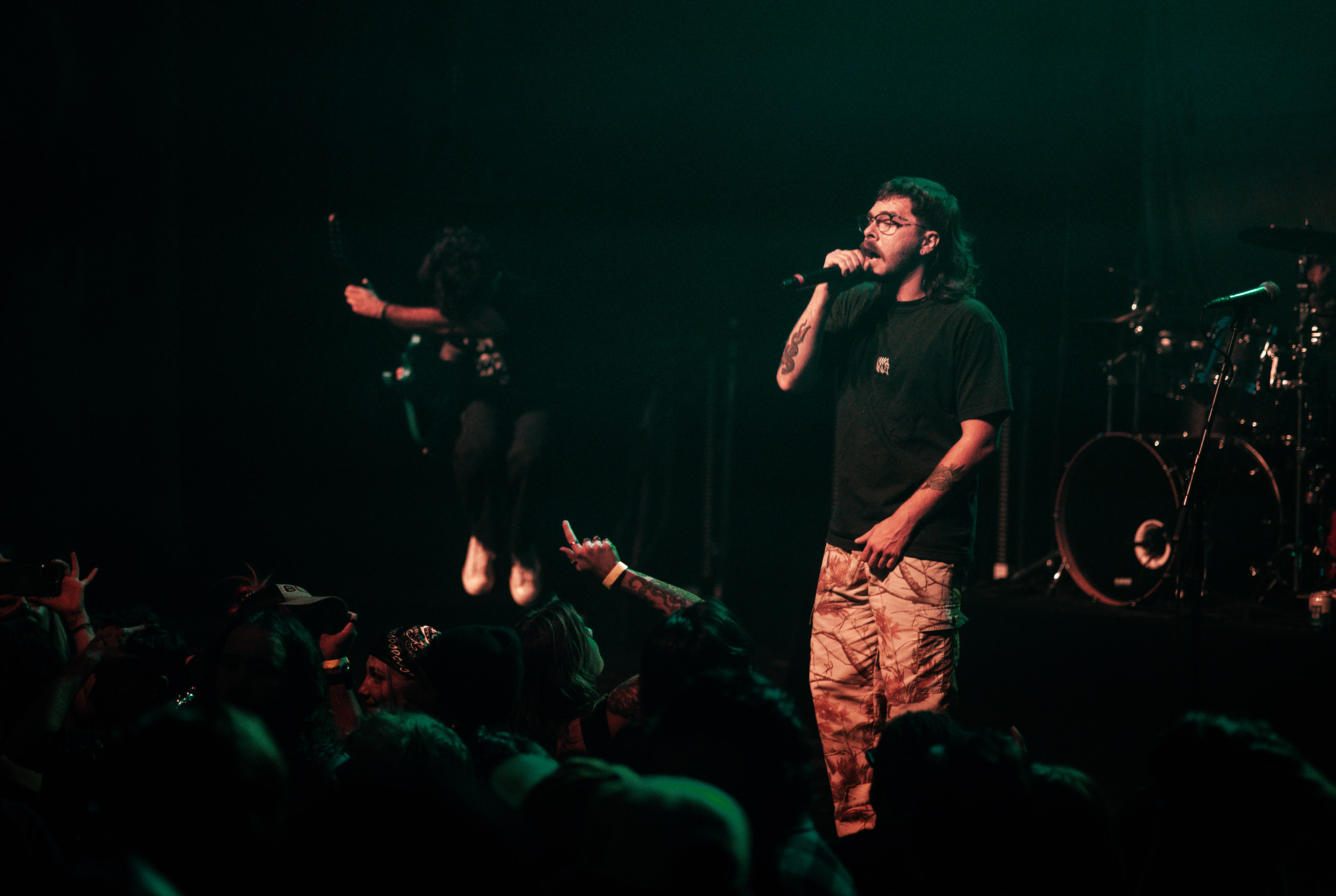Belmont lead vocalist, Taz Johnson, passionately singing into the mic during their Denver concert at The Oriental Theater.