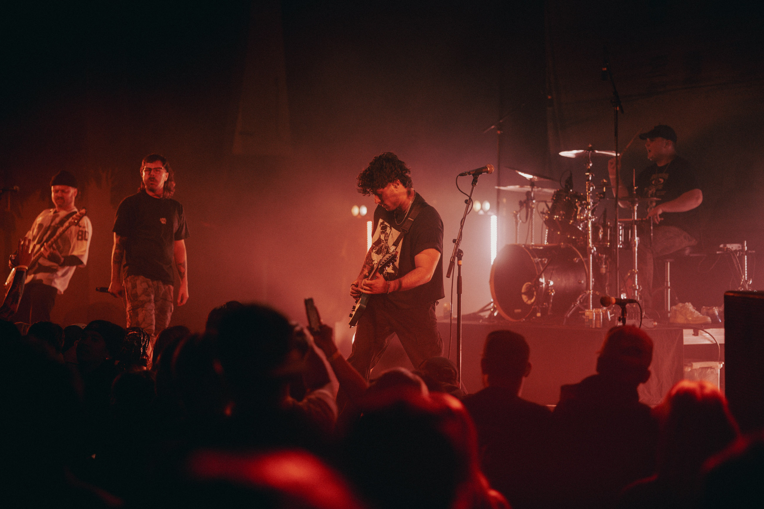 Belmont guitarist playing under stage lights during a live performance in Denver, Colorado.