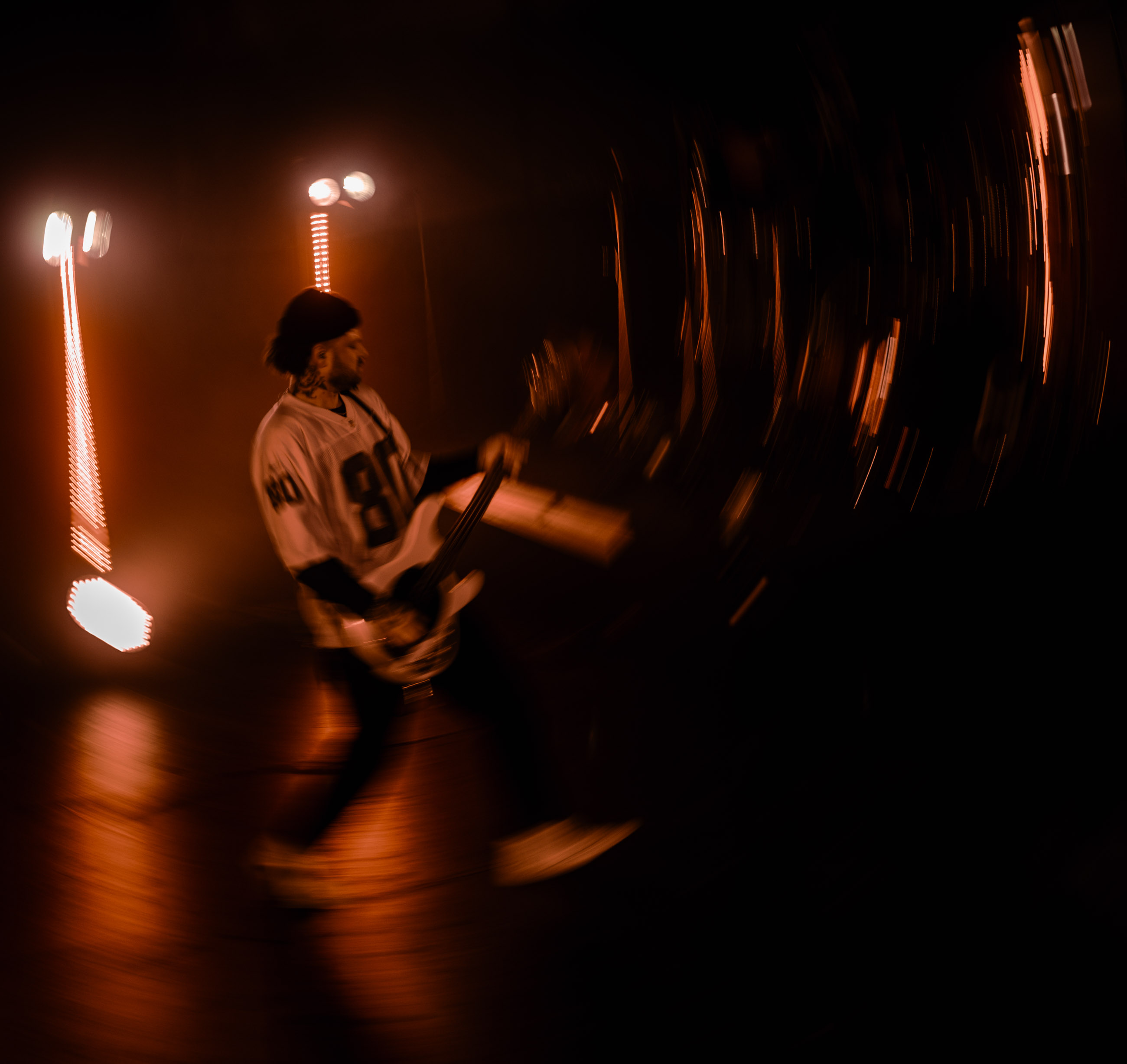 Belmont bassist playing under stage lights during a live performance in Denver, Colorado.
