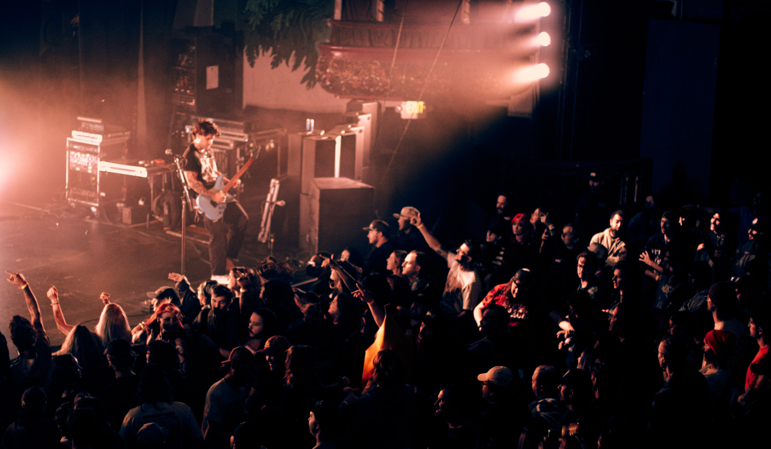 Belmont guitarist playing under stage lights during a live performance in Denver, Colorado.