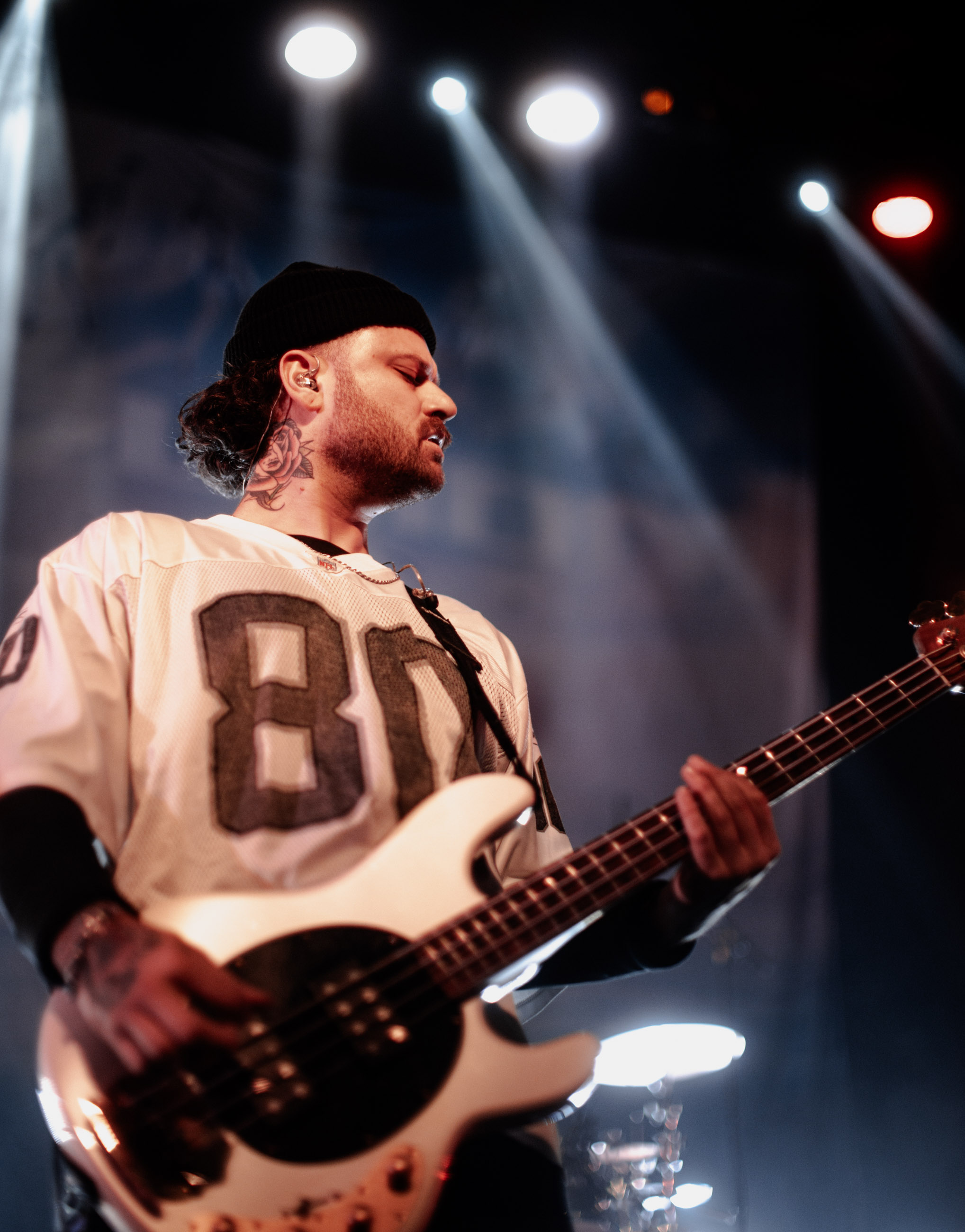 Belmont bassist playing under stage lights during a live performance in Denver, Colorado.
