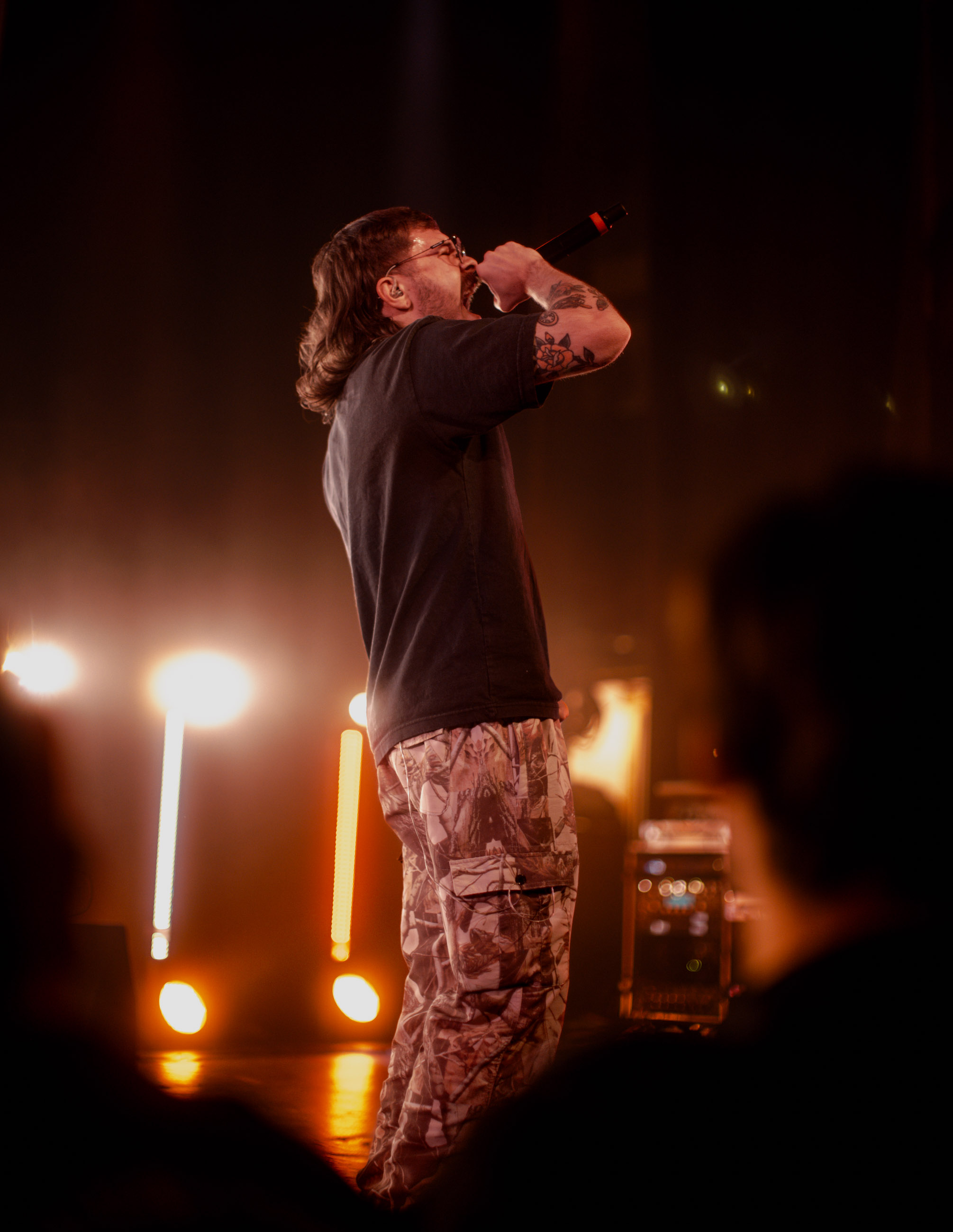 Belmont lead vocalist, Taz Johnson, passionately singing into the mic during their Denver concert at The Oriental Theater.
