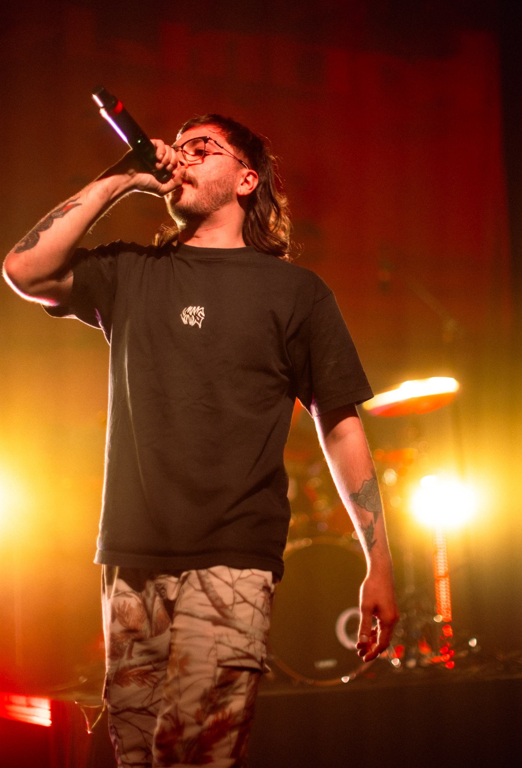 Belmont lead vocalist, Taz Johnson, passionately singing into the mic during their Denver concert at The Oriental Theater.