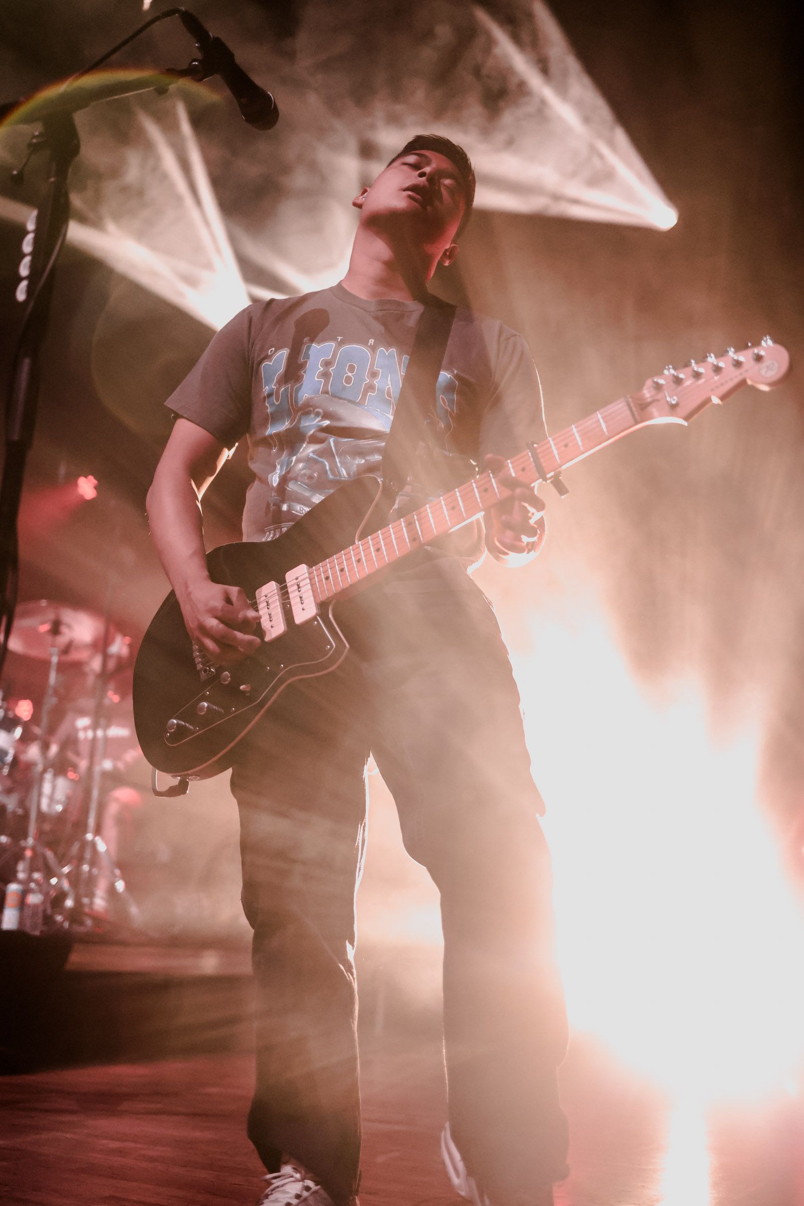 Ryan Malicsi of Hot Mulligan playing guitar under stage lights during a live concert